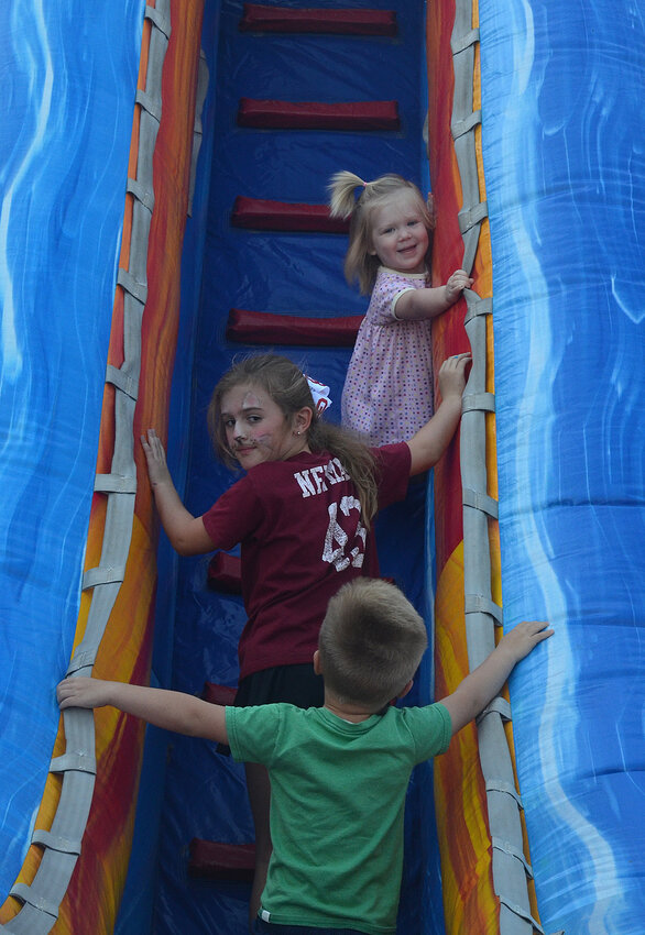 Traffic jam on the bouncy slide. Annie Olson, top, appreciates the patience of Reagan Newman and Coen Olson as they climb the top of a slide.