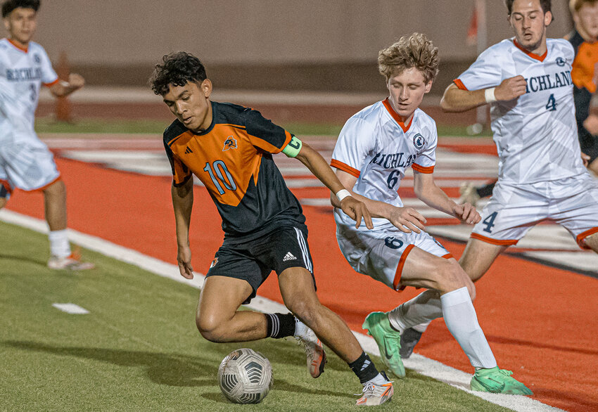 Austin Randriamahefa spins around two Richland defenders before taking a shot at the goal during the Bi-District match at Farrington Field on Thursday, March 20.