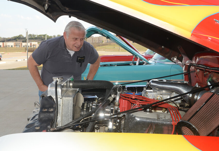 Car enthusiast John Gordon looks at the modified V8 engine of a 1956 Ford F100 displayed by Parker County Cruisers at the Sanctified Hope fundraising banquet on March 25 at Willow Park Baptist Church. Gordon said his own first vehicle was a 1958 Olds 98.