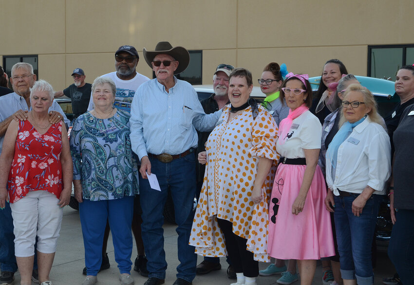 Parker County Cruisers member Red Waller, center with cowboy hat, presents a check for $1,000 to Sanctified Hope workers and volunteers. Parker County Cruisers president James Logan stands behind Waller for the presentation.