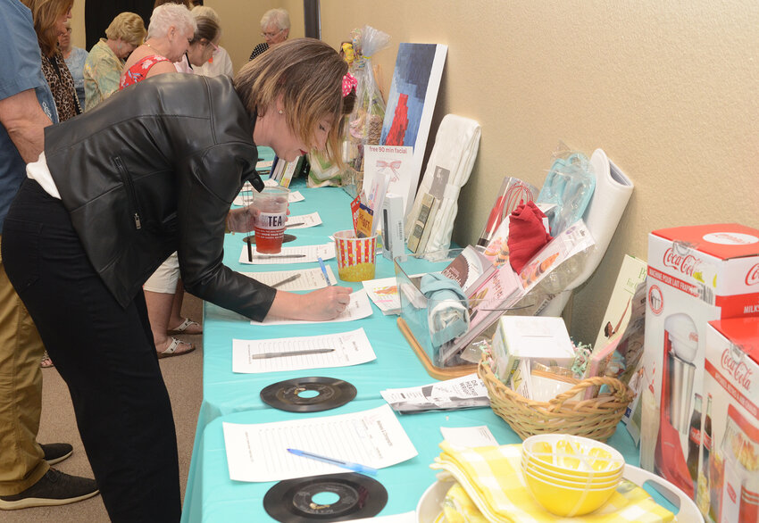 Mary Kathryn Nader enters a bid on a silent auction item.