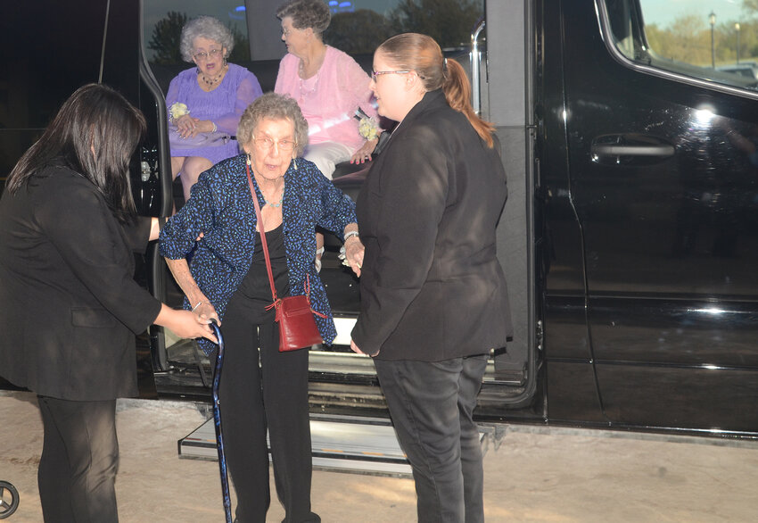 Lennie Harmon exits a deluxe limousine bus at the front door of The Springs Event Venue in Weatherford, an upscale service exclusively for members age 90 and up.