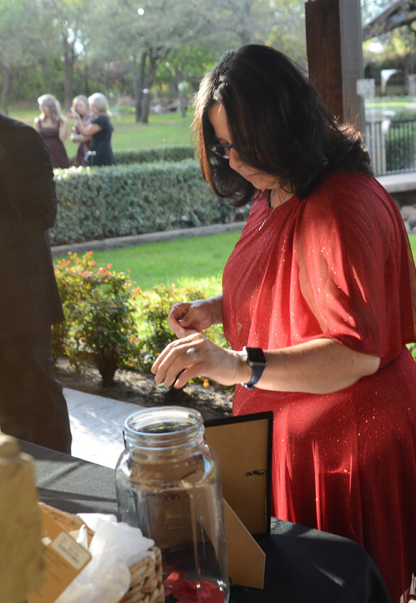 Terri Smith drops a ticket in a jar for a gift basket from Buff City Soap. Funds are raised for Parker County Committee on Aging and Meals on Wheels through raffles, silent auctions, live auctions and table reservations.