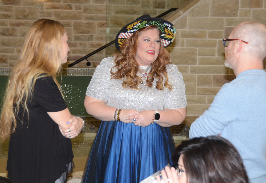 Nicole Eickey of Grace House, center, visits with Erin and Nick Yount.