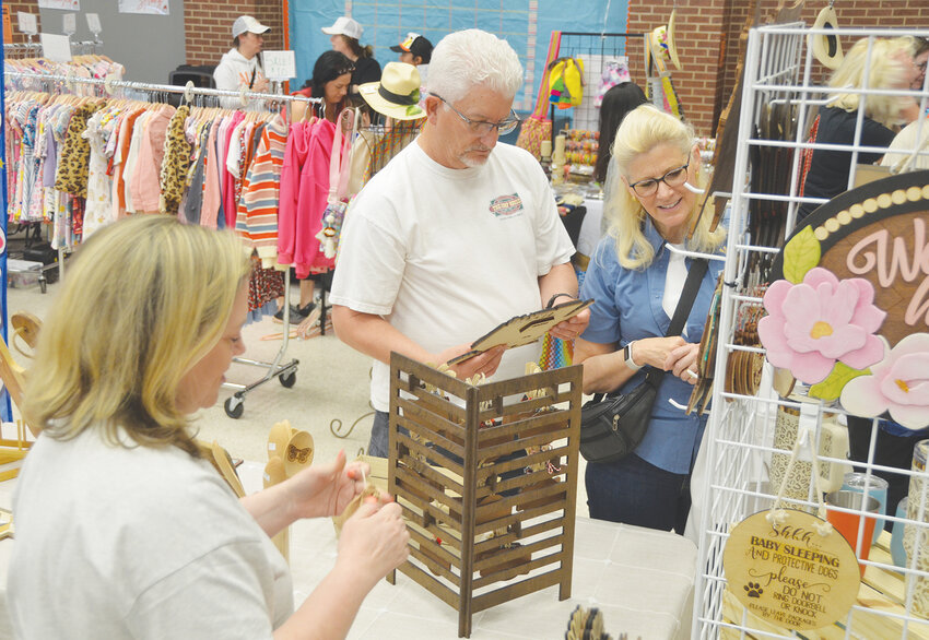 Kevin and Donna Robertson shop at Leanne Barton's booth, Barton House Designs.