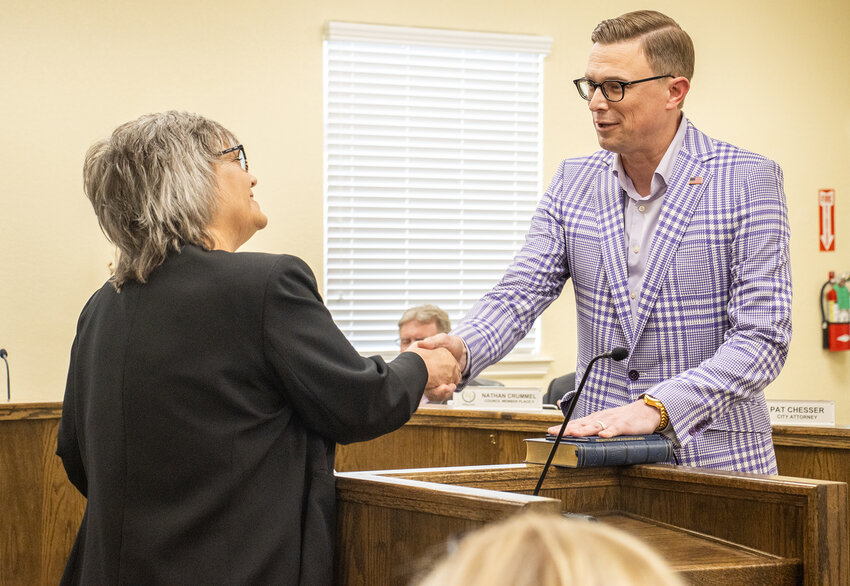 City Secretary Deanna McMullen (left) shakes hands with City Council member Eric Contreras after his swearing in for another term.