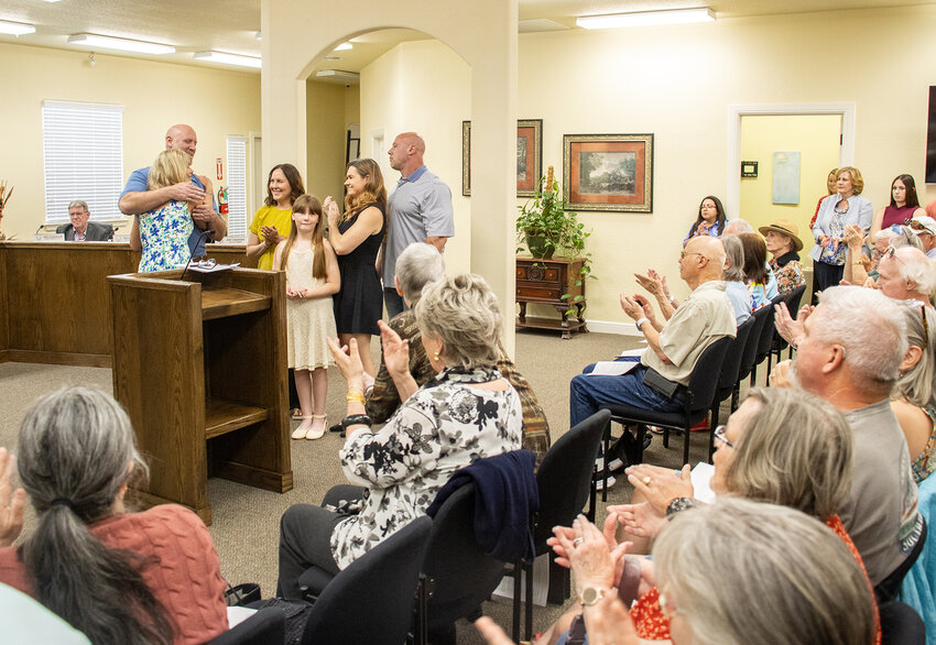 Teresa Palmer hugs her family as the attendees of the city council meeting clap after Palmer's swearing in as mayor of Willow Park.