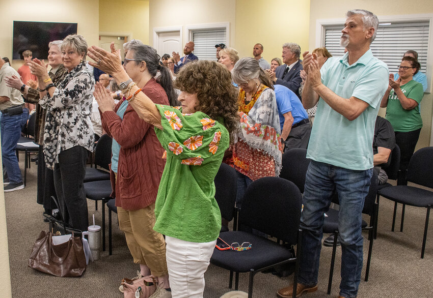 Attendees of the May city council meeting stand and applaud Mayor Teresa Palmers first speech.