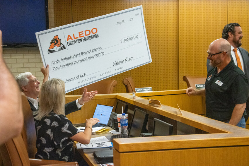 AEF Board President Josh Huxel hands off the check for $100,000 to CFO Earl Husfield.