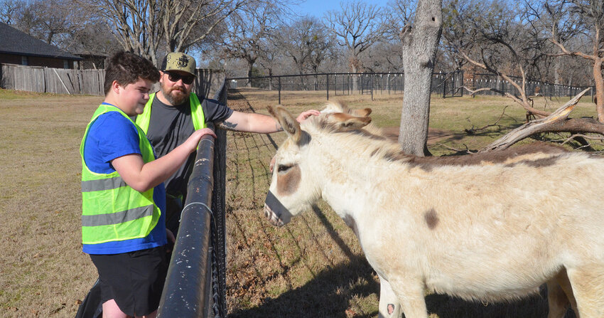 Brandon and Austin Thompson pause from picking up litter in Annetta to make new friends off Old Annetta Road. A dozen volunteers fanned out across Annetta for the city