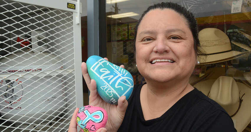 Nishna Mendez of Freedom House of Parker County places painted rocks near the entrance of the Aledo Shell station and convenience store. Rock art is showing up around the county to draw attention to Sexual Assault Awareness Month.