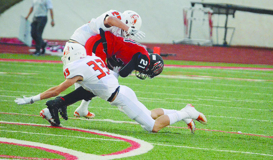 Aledo defenders Logan Childs (33) and Wyatt Harris combine to bring down Colleyville Heritage running back Kam Brown. Childs would later grab an interception that sealed the 41-36 Bearcats' win over the Panthers.