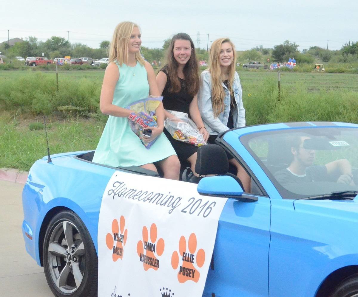 The Aledo High School senior Homecoming Court of Emma Haeussler, Kelsey Basler and Ellie Posey wave to the crowd Monday during the annual Homecoming Parade on the AHS campus. The Bearcats will face Saginaw at 7 p.m. Friday on Homecoming Night at Bearcat Stadium.