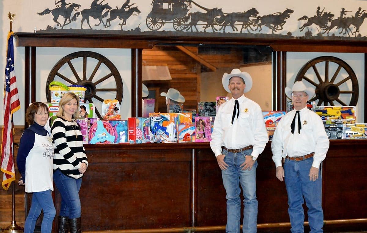 Parker County Sheriff’s Posse Captain Randy O’Neal and Posse Board Member Bill Ward present gifts for 27 children to Santa’s Helpers Co-director Casey Woodard and volunteer Linda Woodard. The donations benefit the Angel Tree for the Salvation Army Manna Storehouse Christmas project.