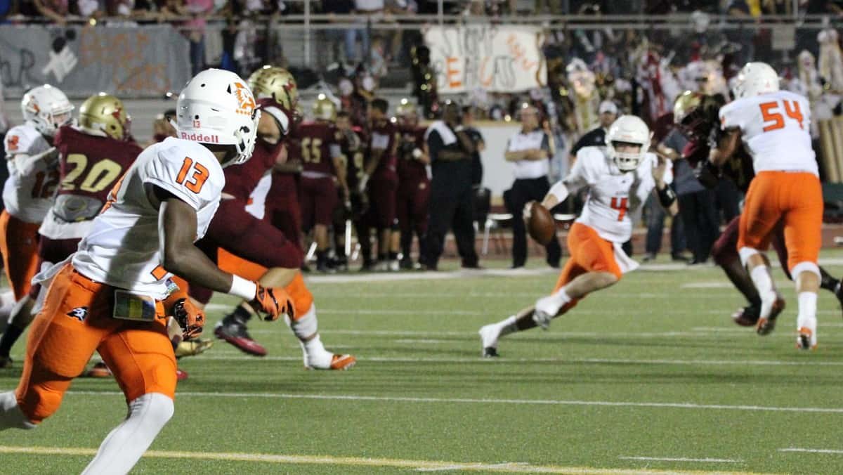 Aledo sophomore quarterback Jake Bishop (4) buys time on a scramble as Money Parks (13) works to get open Friday night during the Bearcats’ win at Saginaw. Photo by Karen Towery