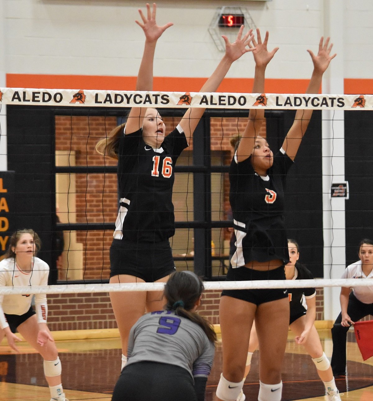 Aledo hitters Lilly Taylor (16) and Audrey Pearce (3) elevate for a block during a recent match. The Ladycats swept Wichita Falls High School Tuesday night at Wichita Falls. Photo by Tony Eierdam