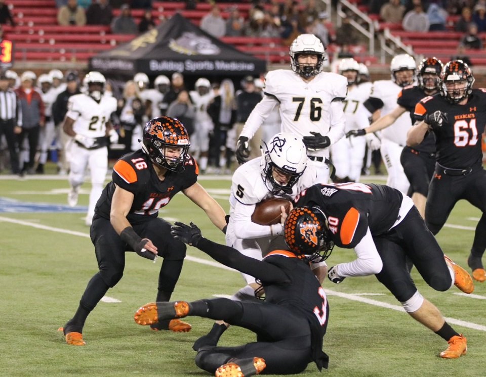 Aledo defenders Kennan Hess (40), Nathen Fingar (3) and Weston Reese (16) converge on Royse City quarterback Tyson Oliver (5) during the Bearcats’ 52-24 victory over the Bulldogs in a Class 5A, Division II area championship game at SMU. Photo by Cynthia Llewellyn
