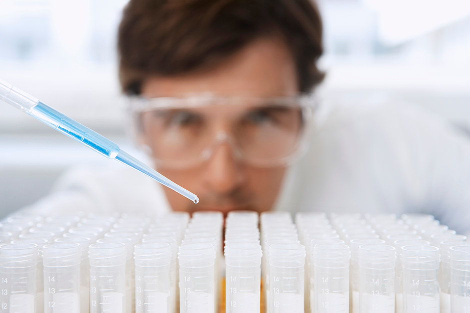 Lab Worker Adding Liquid to Test Tubes
