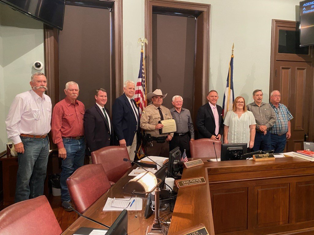 Parker County Sheriff’s Deputy Adam Rozneck (center) was honored by the Parker County Commissioner’s Court on Monday, July 25, for his life-saving actions on July 4.