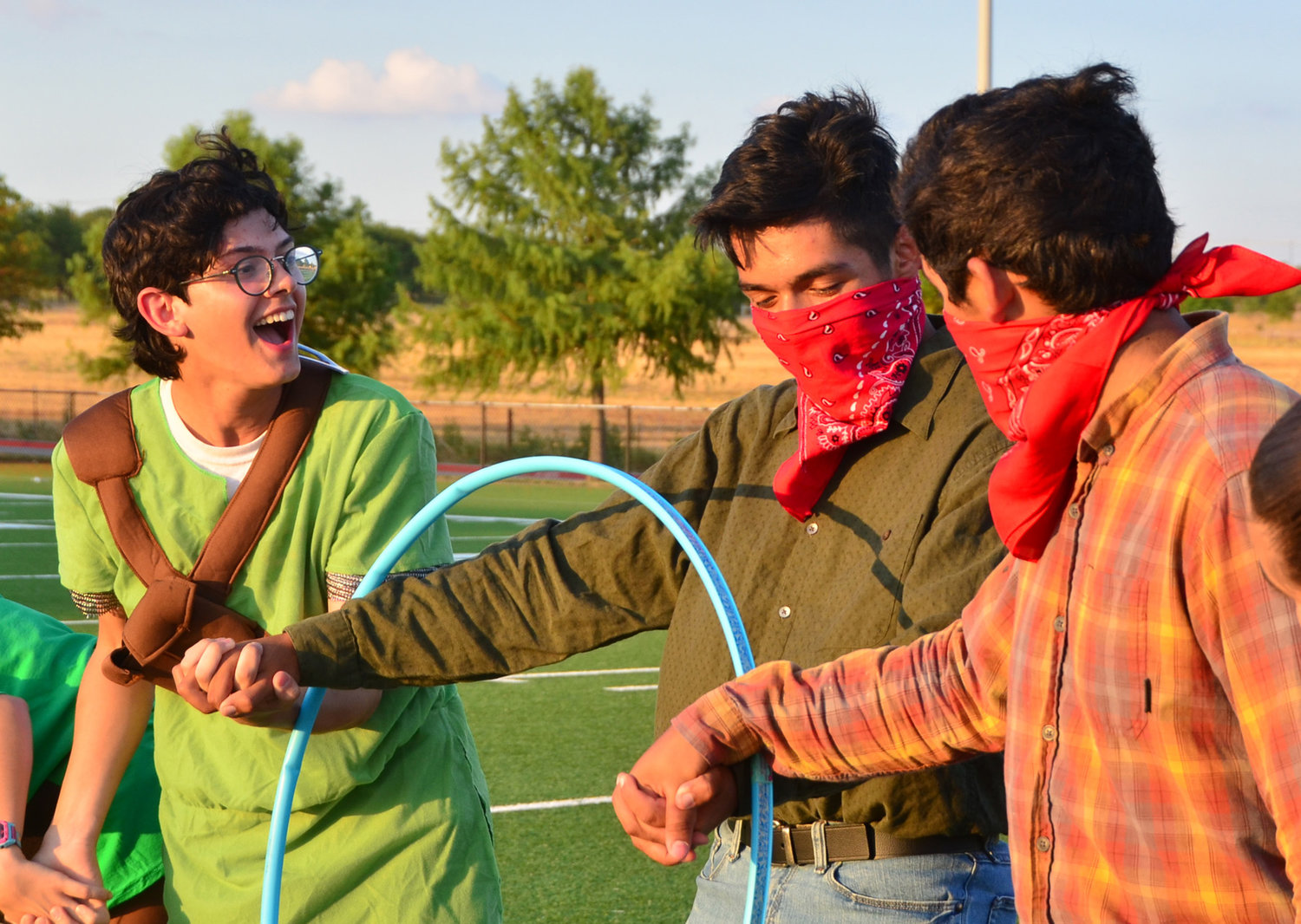 Garhett Daves, Marco Nava, and Jerry Olazaran get tangled up during the Aledo Band Olympics hoola-hoop relay. This is the 20th year for the zany team-building event.