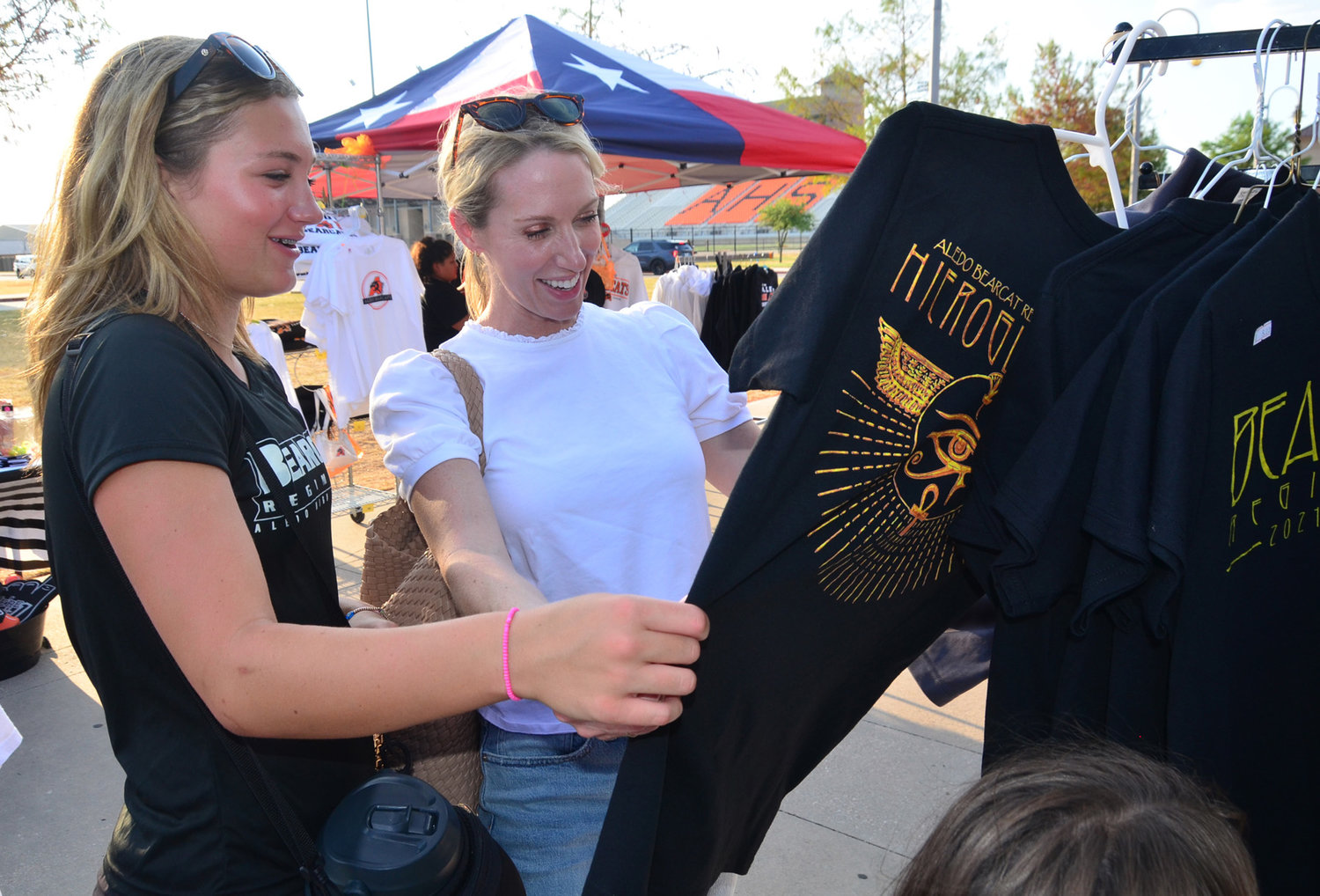 Freshman band member Scarlet Wermuth and mother Tara look through Aledo Band shirts for sale.