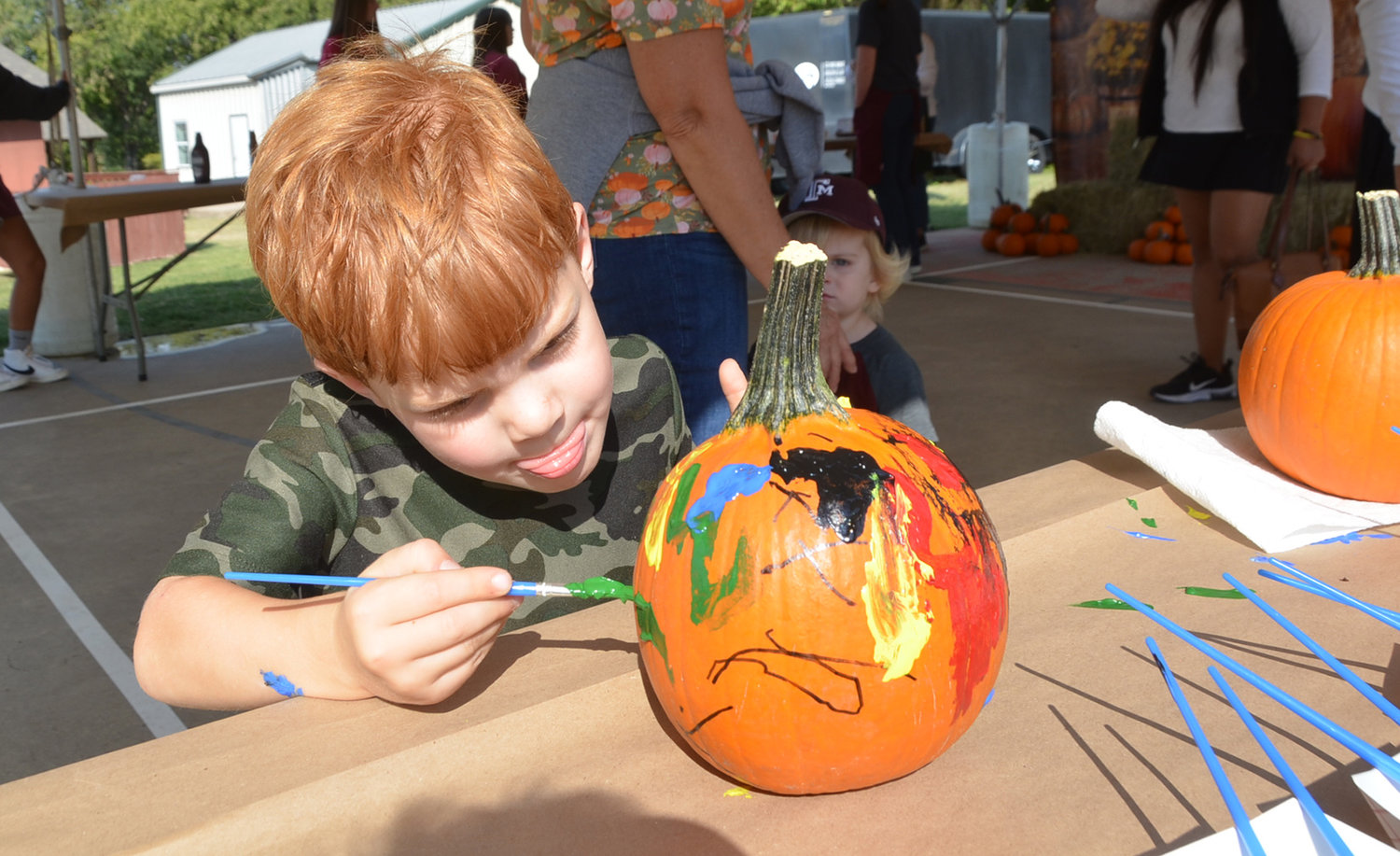 Four-year-old Wyatt Hamende puts the finish touches on a pumpkin masterpiece.