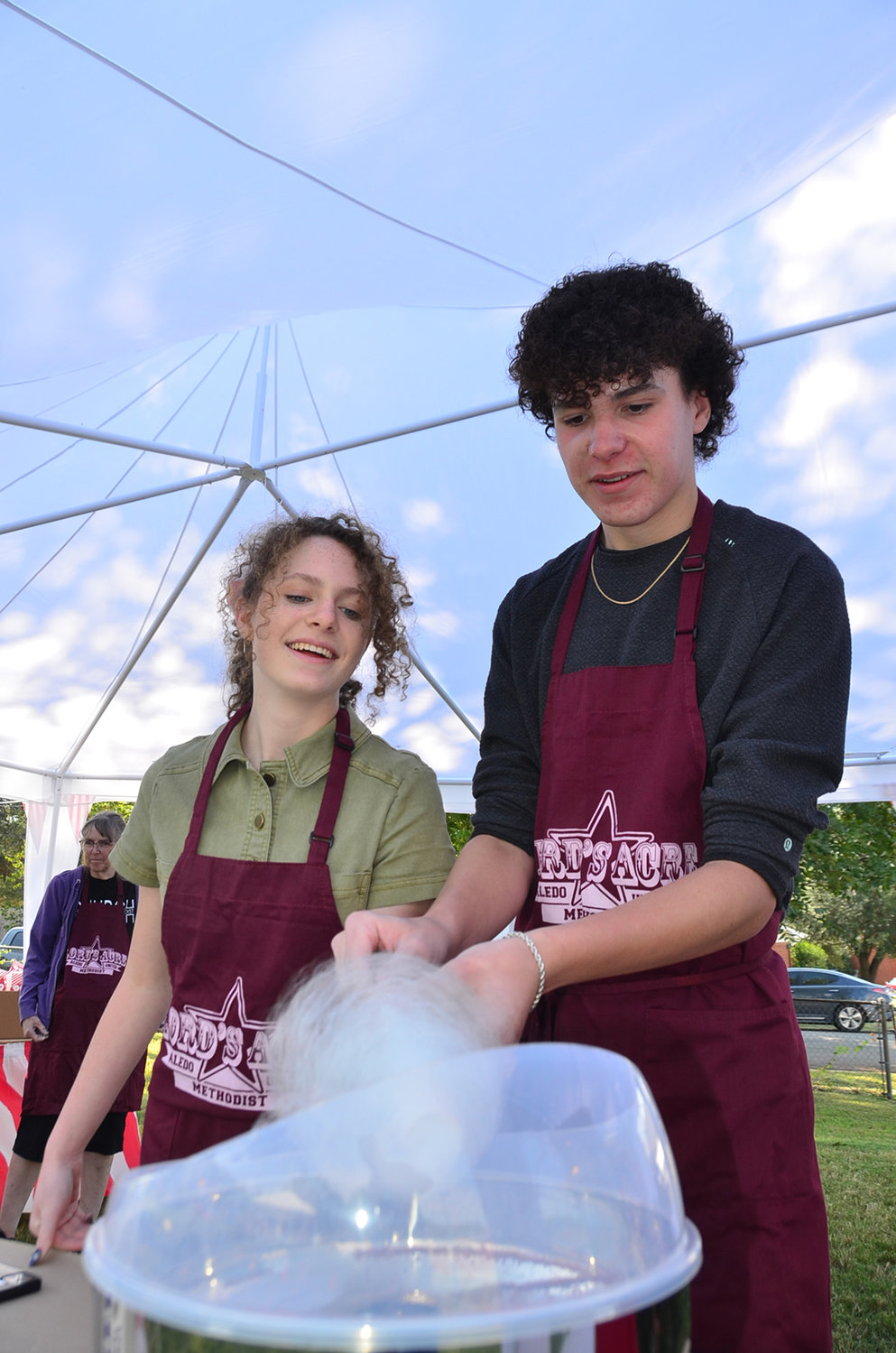 Volunteers Magan and Gregg Babcock spin cotton candy.