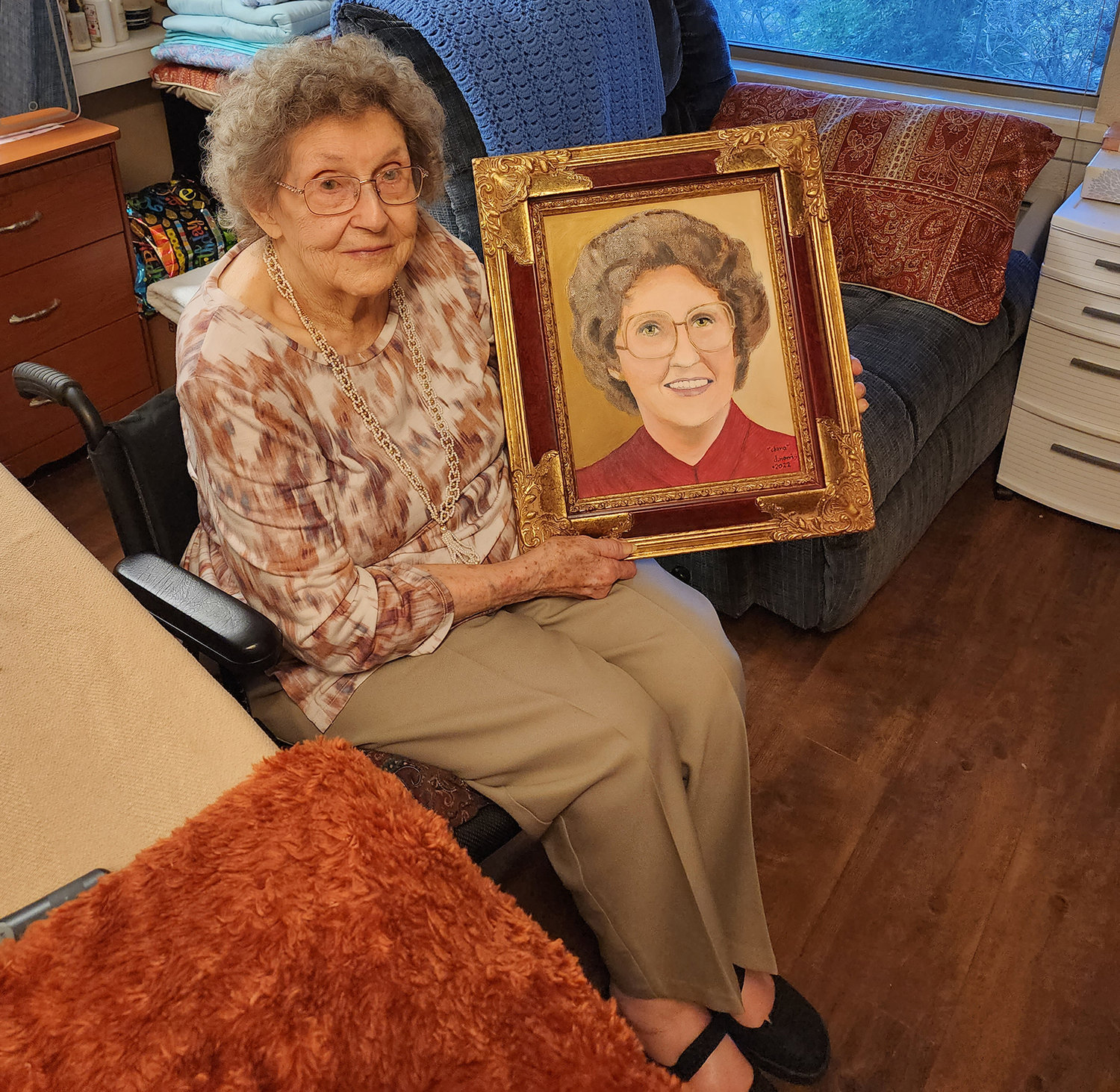 Clara Whisenant holds a painting of herself in her younger days created by an old friend, Daniel Norris. He worked for she and her husband Ray when they owned the Mobile station near downtown Aledo and it was a present for her recent 100th birthday.