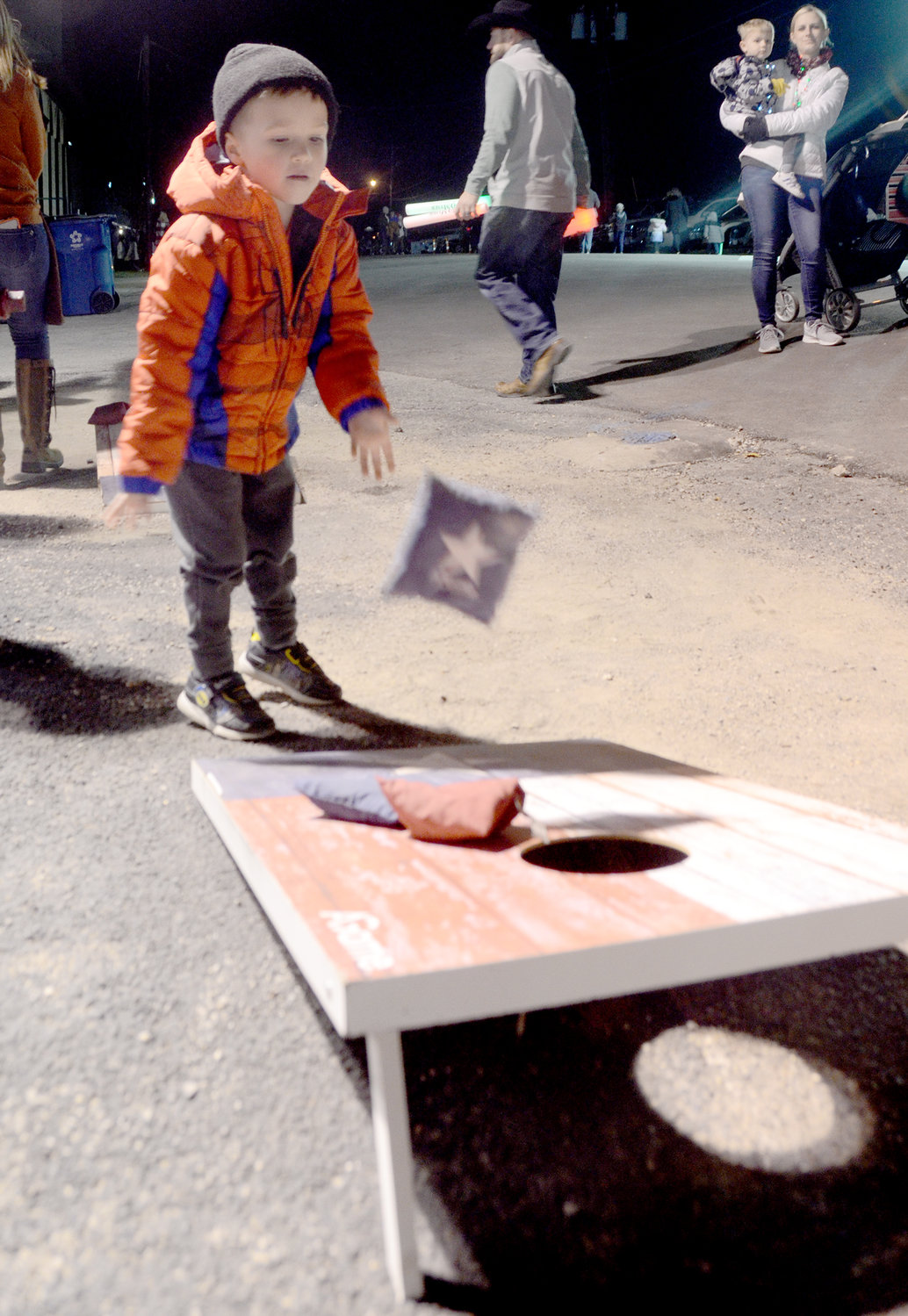 Four-year-old Lucas Welch enjoys the corn hole toss.