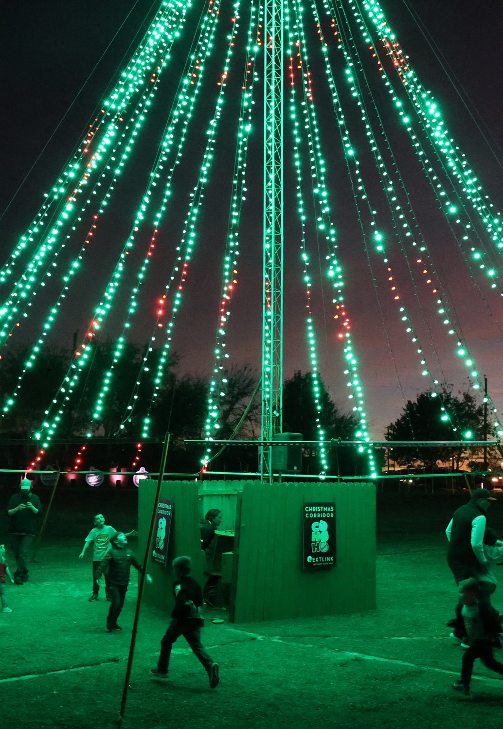 Children frolick amid the giant Christmas tree of light in the middle of Gene Voyles Park.