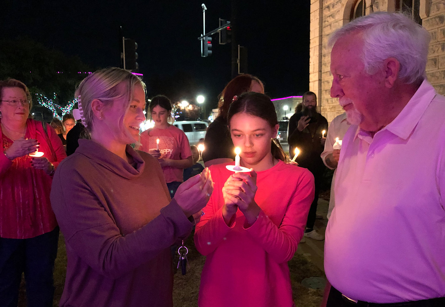 Leslie and Ella Folsum were among the people who gathered to show support for the family of Athena Strand at a Tuesday night vigil. They are shown speaking with Van Houser, pastor at North Side Baptist Church in Weatherford.