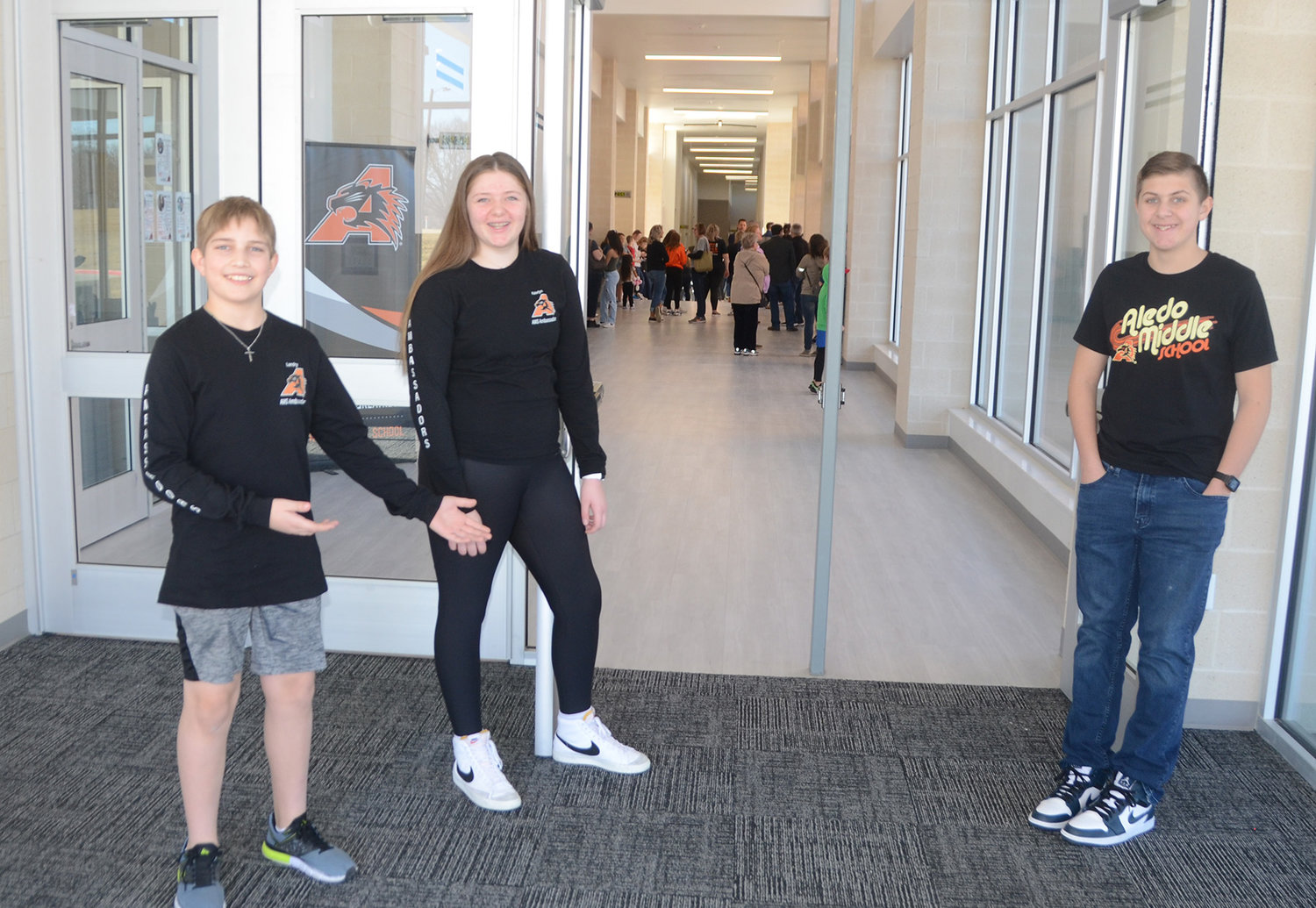 Seventh-graders Landry Kasper and Katlyn Lowe and eighth-grader Kale Roberson greeted guests Sunday at the ribbon cutting ceremony and open house of the newly-renovated Aledo Middle School.