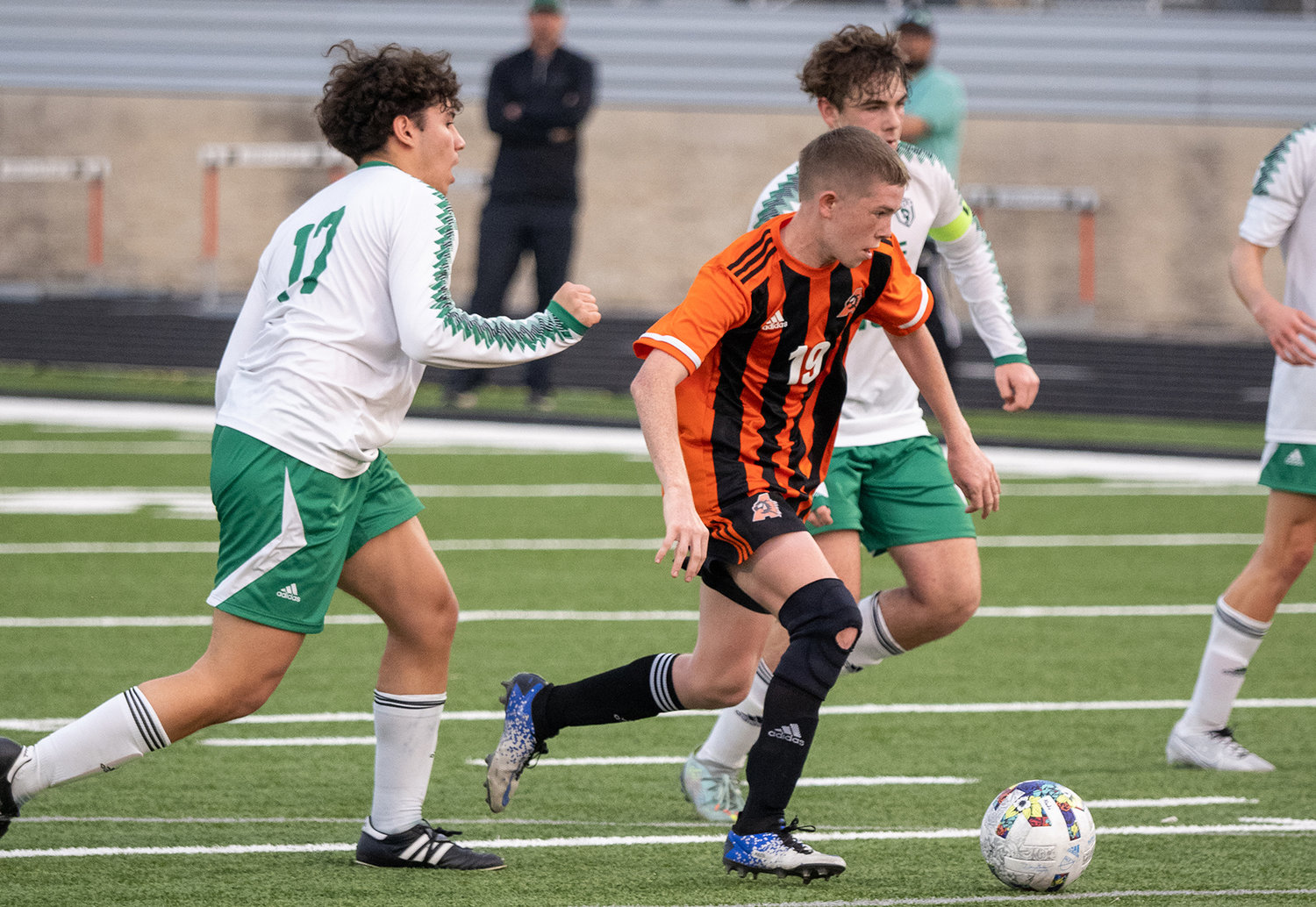 Robby Sloan drives passed a pair of Azle defenders during the second half of the match on Tuesday, March 7.