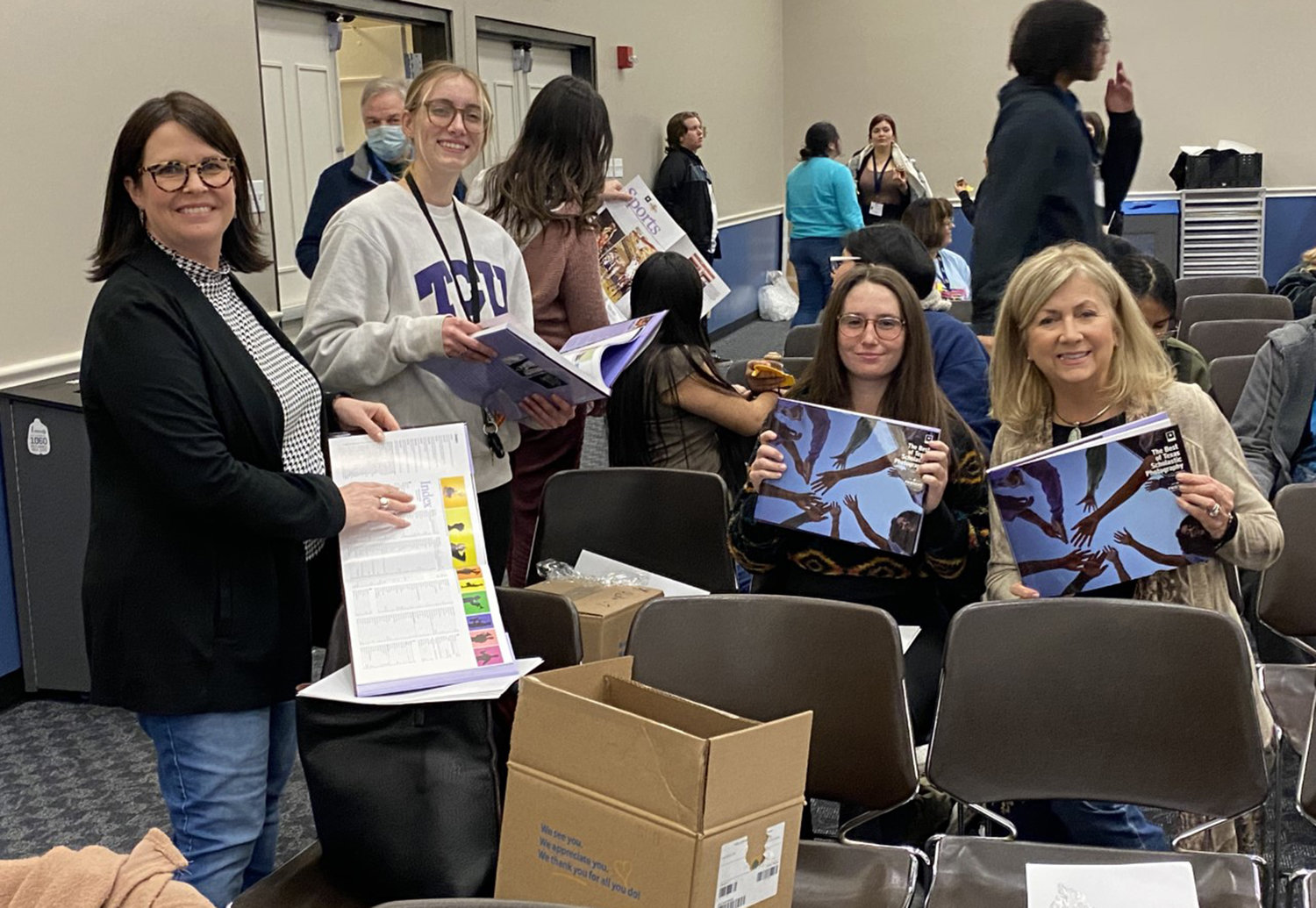 Aledo ISD instructor Emily Arnold, AHS seniors Kaylee Halfmann and Taylor Tiberg, and instructor Linda Greenwood look over volume five of The Best of Texas Scholastic Photography.