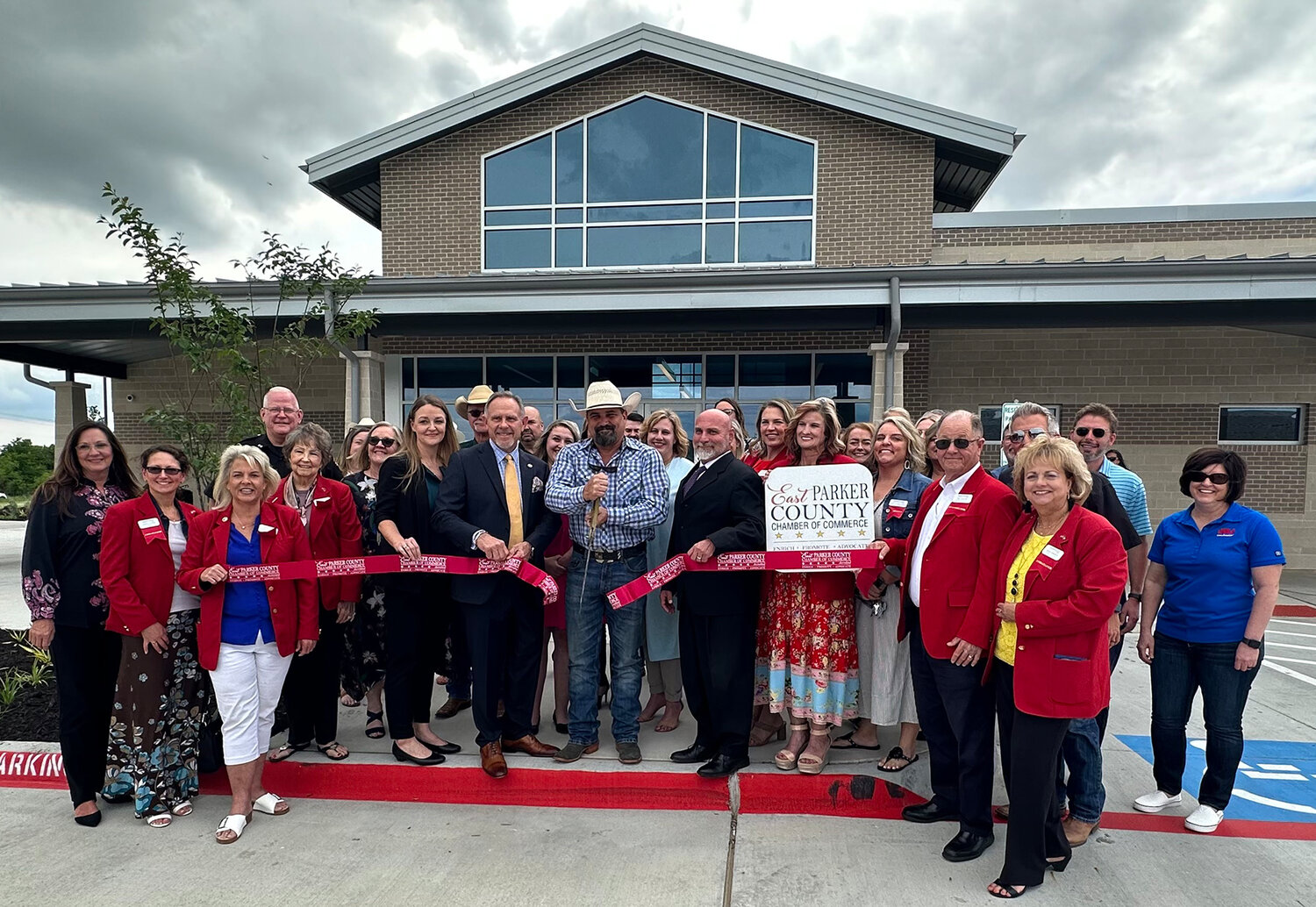 The East Parker County Chamber of Commerce held a ribbon cutting at the new East Parker County Sub Courthouse on Tuesday, May 16. County officials shown in front are (from left) Tax Assessor-Collector Jenny Gentry, County Judge Pat Deen, Pct. 4 Commissioner Mike Hale (cutting the ribbon), and Pct. 4 Justice of the Peace Tim Mendolia.