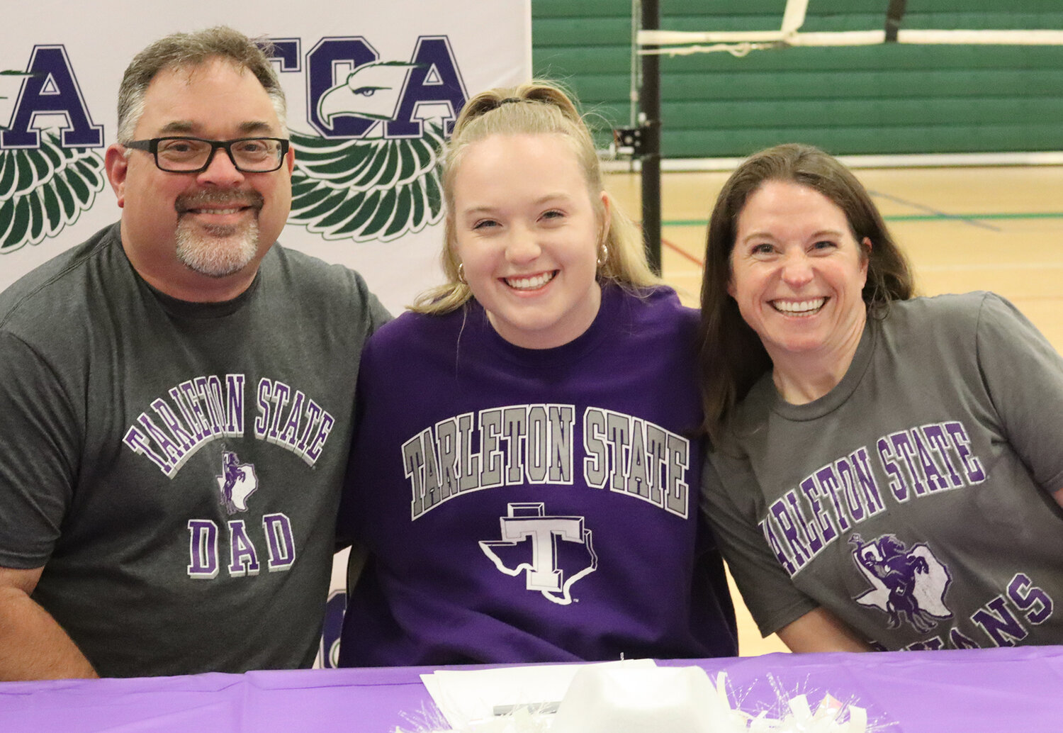 Abby James is shown with her parents as she signed to be on the cheerleading squad at Tarleton State University.