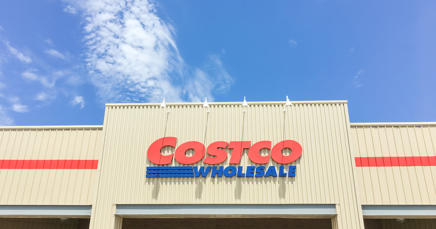 Lewisville, TX, USA- APR 20, 2018: Logo of Costco storefront, close up facade entrance cloud blue sky. Wholesale Corporation is largest membership-only warehouse club in USA, 705 warehouses worldwide