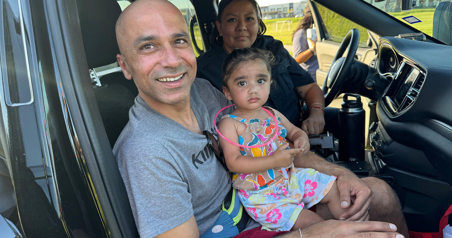 Vic Kapur and daughter Zoe check out the inside of a police car.