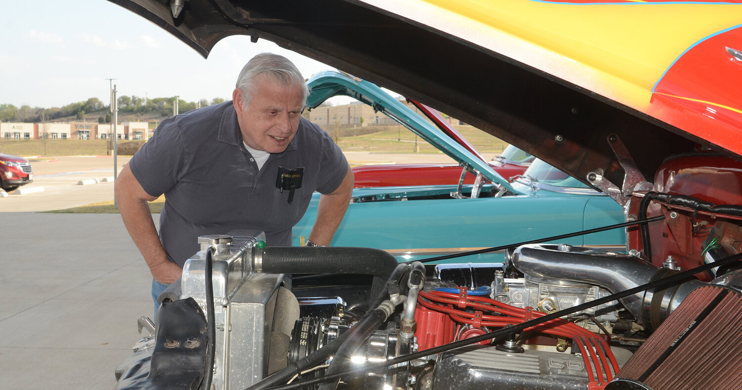 Car enthusiast John Gordon looks at the modified V8 engine of a 1956 Ford F100 displayed by Parker County Cruisers at the Sanctified Hope fundraising banquet on March 25 at Willow Park Baptist Church. Gordon said his own first vehicle was a 1958 Olds 98.