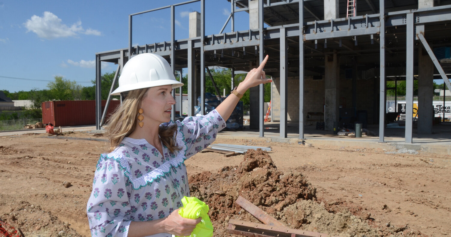 Laura Weber points out where the city council chambers will be at the new city hall, to the right of the building from the main entrance.