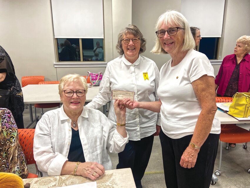 Susan Donnelly (seated), Beverly Markland, and Pat Hilgedick accept a check from P.E.O. on behalf of the Christmas Holiday House in Fayette. All three are members of both P.E.O. Chapter AU and the Holiday House.