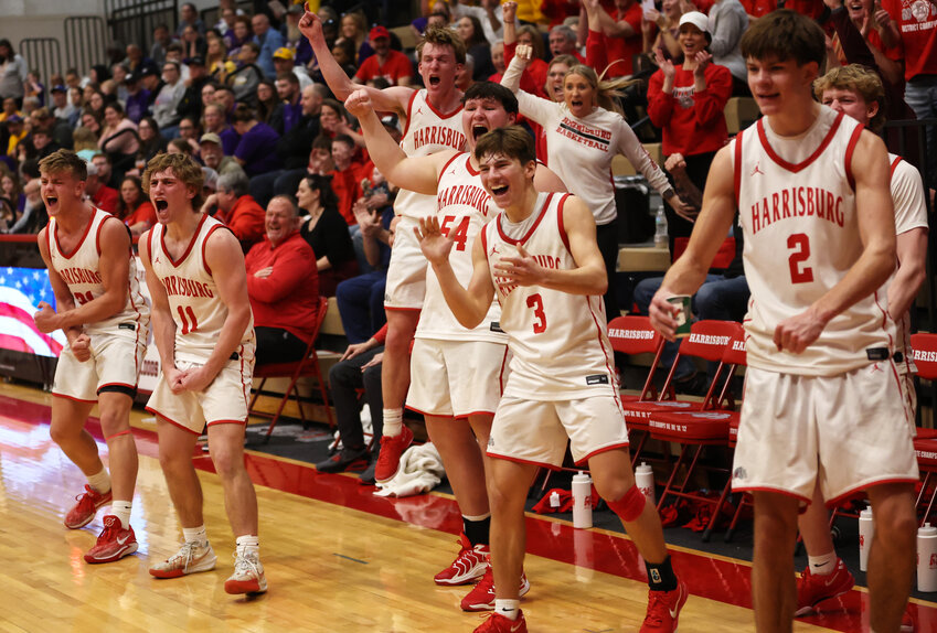 With the state sectional win secured late in the fourth quarter, the Harrisburg varsity players erupt from the bench as freshman Silas Buckler sinks a bucket and draws a foul.