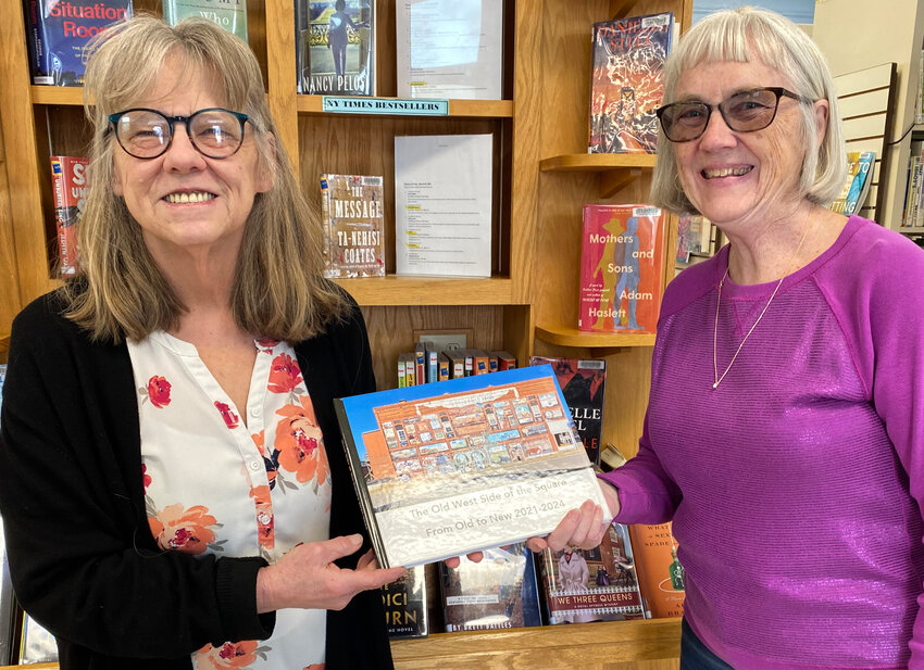 Chris Kloeppel (left) of the Howard County Library District accepts a copy of “The Old West Side of the Square: From Old to New 2021-2024,” from author/photographer Pat Hilgedick (right).