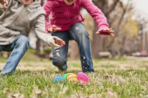 Two children running towards easter eggs