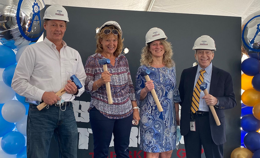 Members of the Pine Bush Central School District Board of Education as well as past and present district administrators pose for a photograph after breaking through the skills gap barrier with mallets. From left to right: Board Member Matthew Watkins, former Assistant Superintendent for Instruction Donna Geidel, Board President Gretchen Meier and Superintendent Tim Mains.