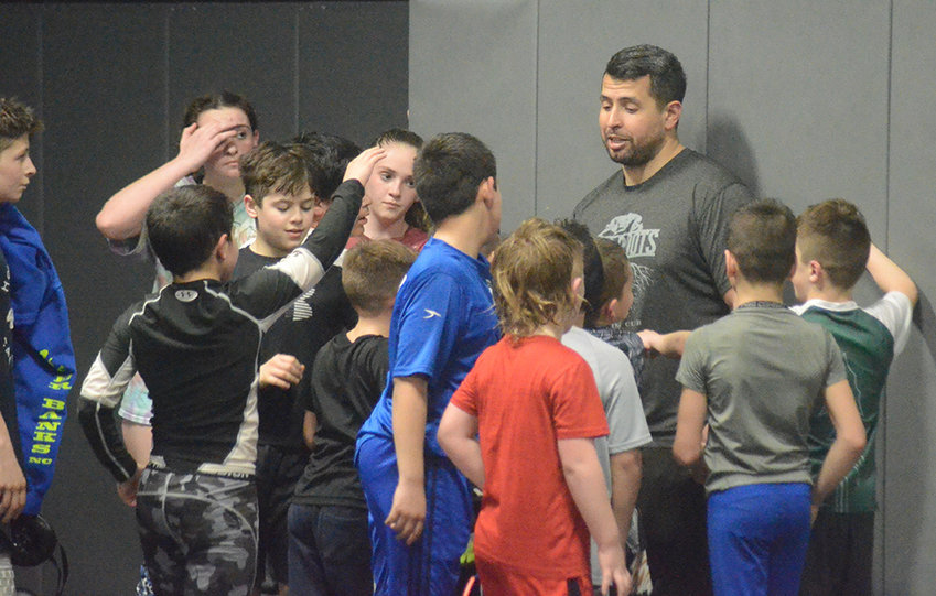 Deep Roots Wrestling Club coach Ricky Scott talks to the youth wrestlers after Thursday&rsquo;s practice at the club&rsquo;s facility in Walden.
