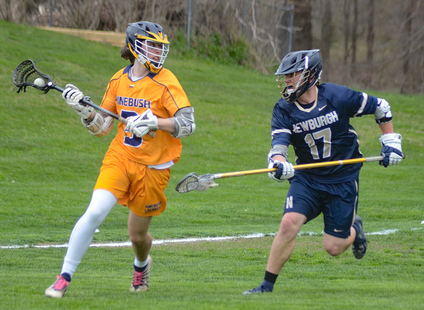 Pine Bush&rsquo;s Danny DeGroodt moves the ball around the back of the cage as Newburgh&rsquo;s Aiden Harrison defends during Thursday&rsquo;s boys&rsquo; lacrosse game at Pine Bush Elementary School.