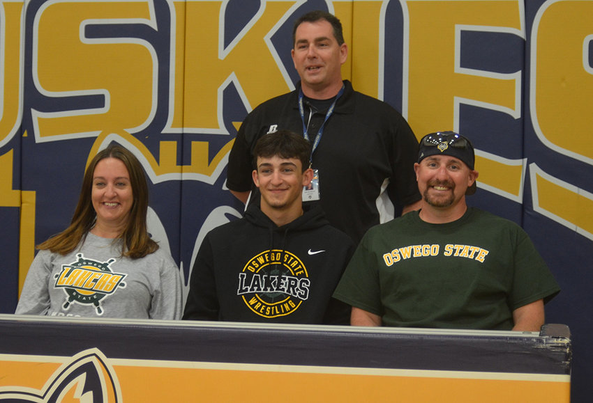 Highland&rsquo;s Chris Gatto is shown with his parents after being honored on Wednesday at Highland High School for committing to wrestle at SUNY Oswego. Highland wrestling coach John McFarland is in back.