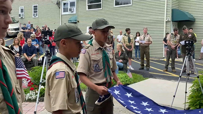 Scouts demonstrate the proper technique for folding a flag at Sunday&rsquo;s ceremony in Walden.
