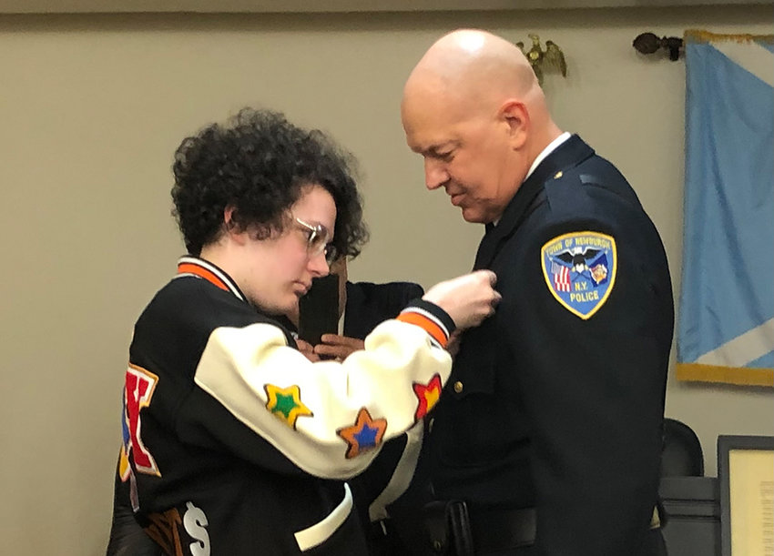 Robert DeSaye [right] is pinned with a police shield on his uniform by daughter Erica.